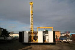 Acumen Machine yellow crane inside storage container