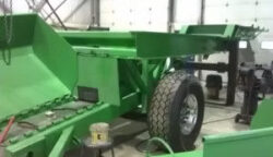 Acumen Machine repairing green hopper on wheels in shop